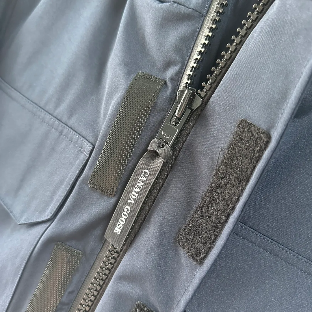 P700 CANADA GOOSE｜Canada Goose Expedition Parka｜Classic upgrade New 08 style Color: graphite gray, off-white, black, pink, navy blue, sky blue, Size: XS, S, M, L, XL, XXL, Product introduction Loose fit, multi-pocket design Larger size for free movement. 6 exterior pockets: 4 reversible front pockets, zippered side entry. There is a practical pocket on the left sleeve and a top pocket on the right sleeve. There is a drawstring on the inside of the waist and a logo patch on the back. The waist is designed with an inside drawstring, which can be adjusted to provide excellent warmth. Woven grab straps at upper back with “Expedition” logo patch • Hood with removable zipper trim, interchangeable hood trim for personalization and added protection (this jacket is not available with the classic hood trim) • Chin protection element has a tricot inner fabric for softness and comfort • Woven grab straps at upper back with “Expedition” logo patch • Internal drawstring at the waist, adjustable to provide excellent warmth •Snap-in rib knit cuffs for added comfort and optimal heat locking in •Stylish hanging inner straps allow the jacket to be carried over the shoulder, hands-free •Stowaway nylon stretch snow skirt for added protection •Two-way zipper covered fly with Velcro® snaps that unzips from the bottom for increased range of motion and breathability. A windproof fly is designed under the zipper for an extra layer of protection. • 6 exterior pockets: 4 two-way pockets on the front with top flap and Velcro® snaps, and zippered side entry. Utility pockets on left sleeve and right sleeve with top flap and velcro® snaps Internal pockets: 1 zipped pocket, 2 mesh drop-in pockets Embroidered Canada Goose logo